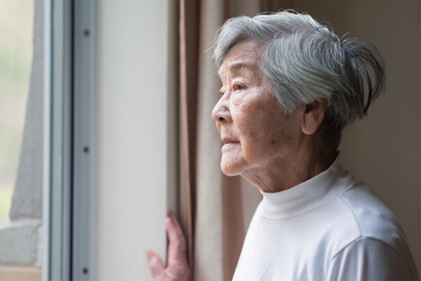 Elderly woman looking out window